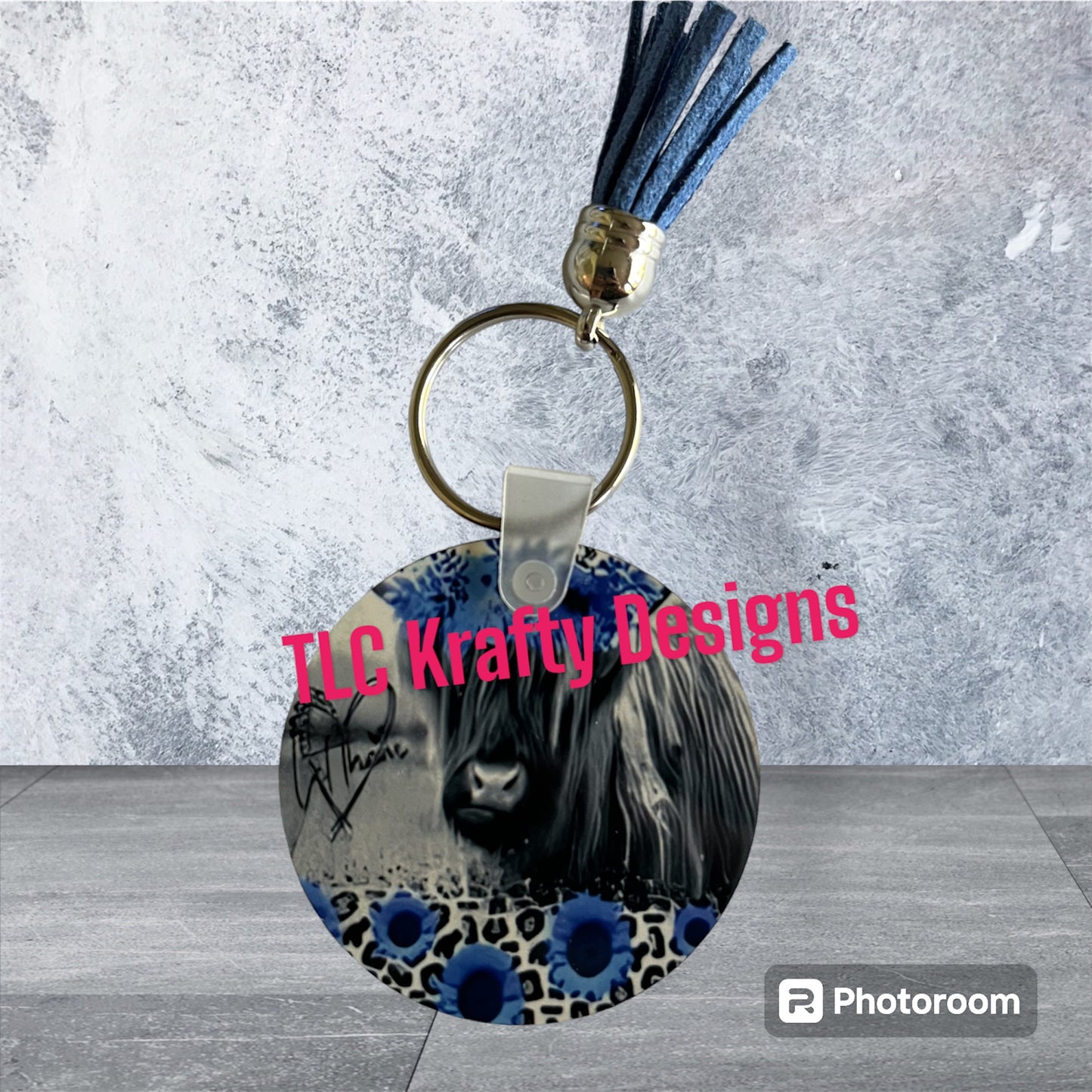 Highland Cow surrounded black and white flowers with a hint of blue Keychain with Tassel