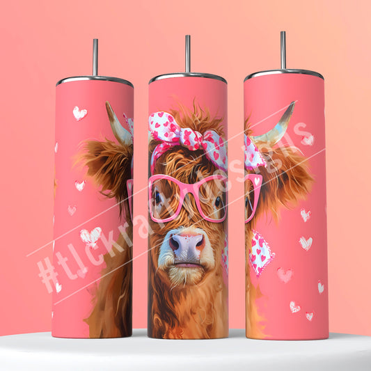 Delightful sublimation tumbler with a charming pink background, showcasing a highland cow adorned with reading glasses and a whimsical bow around its head