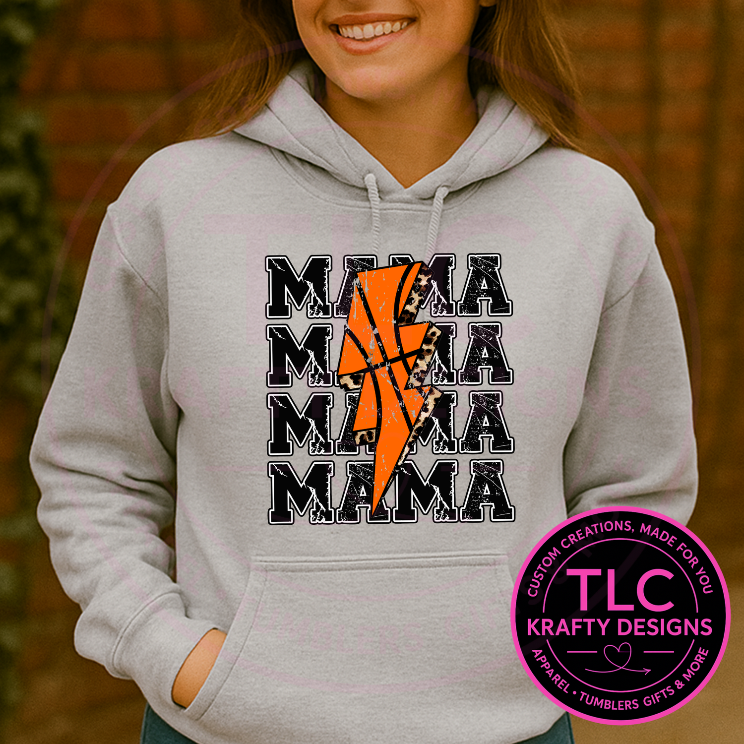 Person wearing a gray hoodie with 'MAMA' text and basketball design, with TLC Krafty Designs logo.