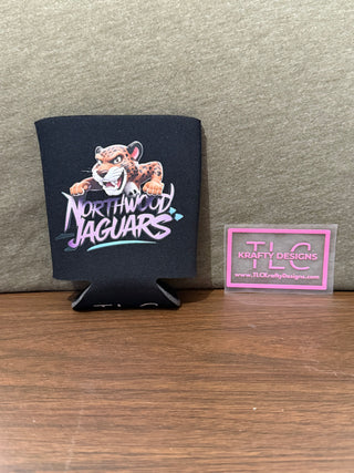 A black neoprene can koozie with a printed logo of the Northwood Jaguars, placed on a wooden surface, with a business card for 'TLC Crafty Designs' next to it.