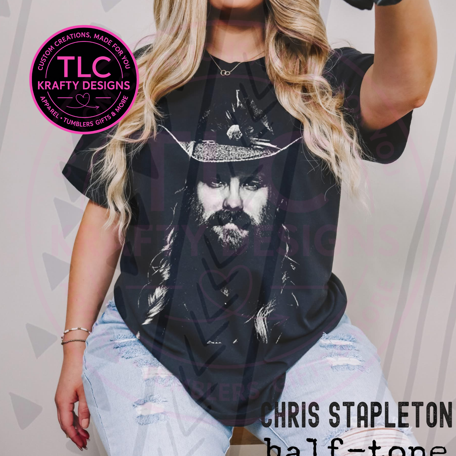 Person wearing a black t-shirt with a graphic design of a bearded man, sitting against a neutral background.