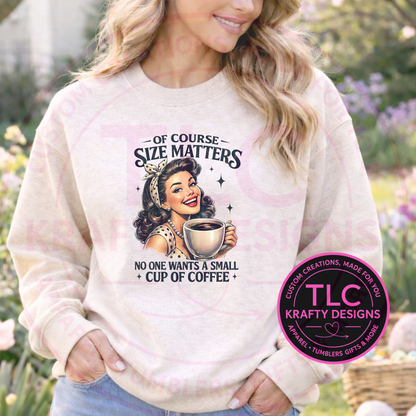 Woman wearing a sweatshirt with a coffee-themed of course size matters no one wants a small cup of coffee graphic and 'TLC Krafty Designs' logo.