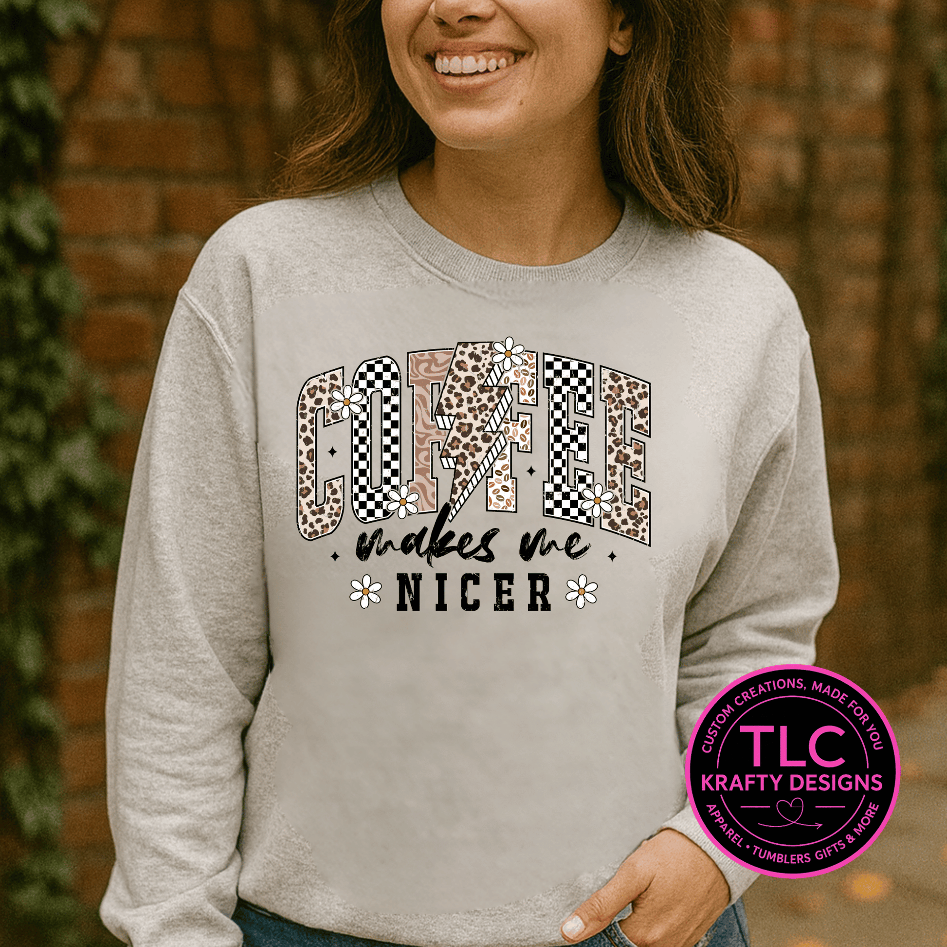 Person wearing a gray sweatshirt with a colorful graphic and text, standing against a brick wall.