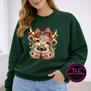 Highland Cow Christmas Bow design on a forest green crewneck sweatshirt