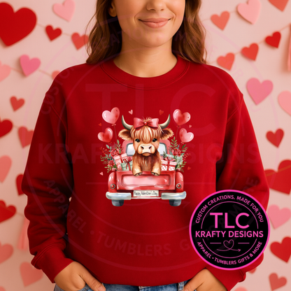 Person wearing a red sweatshirt with a cow in a truck graphic, surrounded by hearts, against a heart-patterned background. TLC Krafty Designs logo visible.