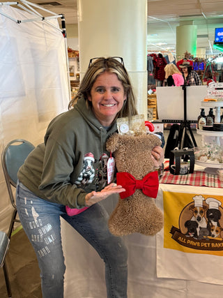 Brown Dog Bone stocking filled with treats, held at the All Paws Pet Bakery booth