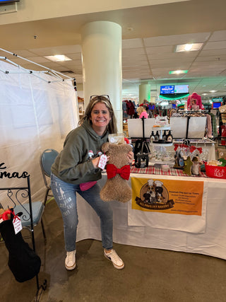Brown Dog Bone stocking filled with treats, held at the All Paws Pet Bakery booth